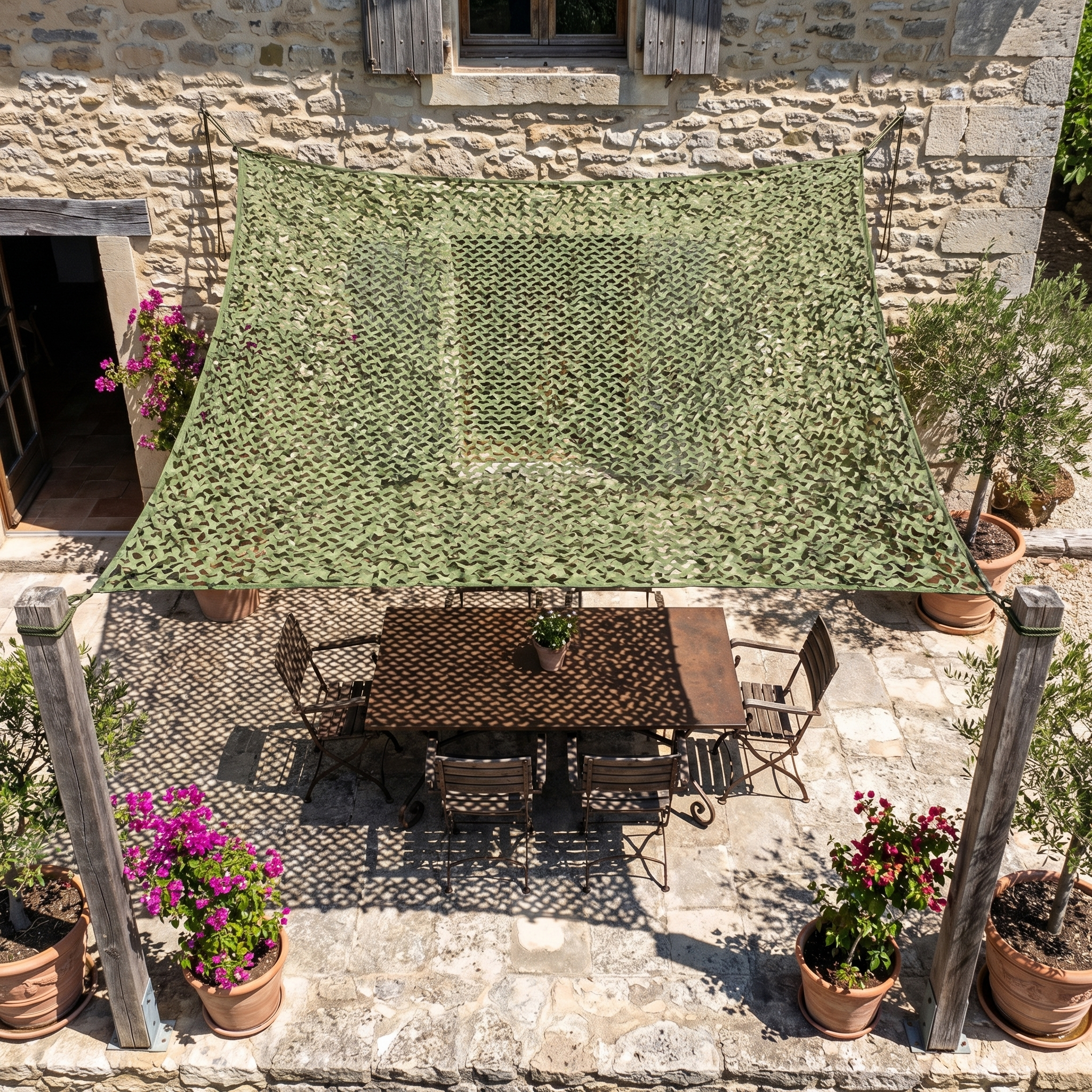 TheFrenchNets olive reinforced shade net anchored between two trees on a terrace.