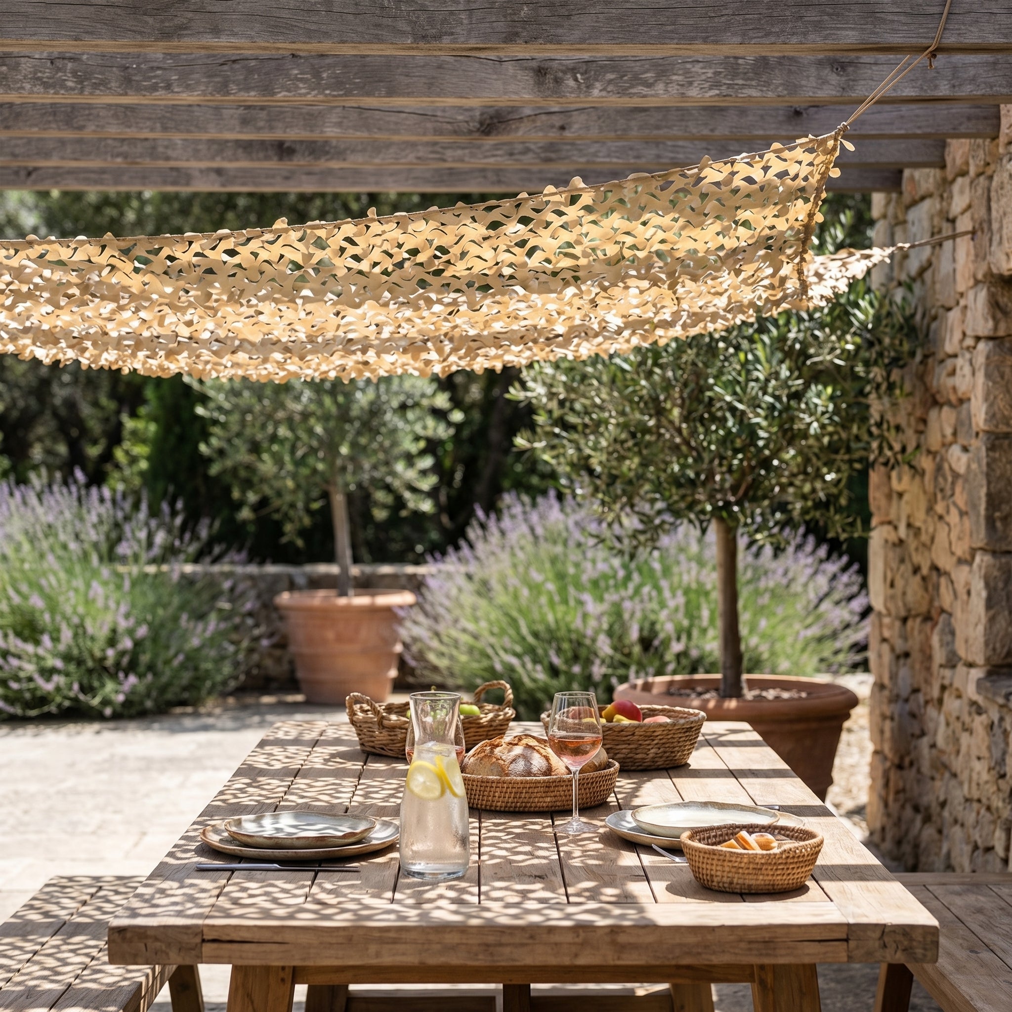 TheFrenchNets sand reinforced shade net above a Mediterranean stone courtyard.