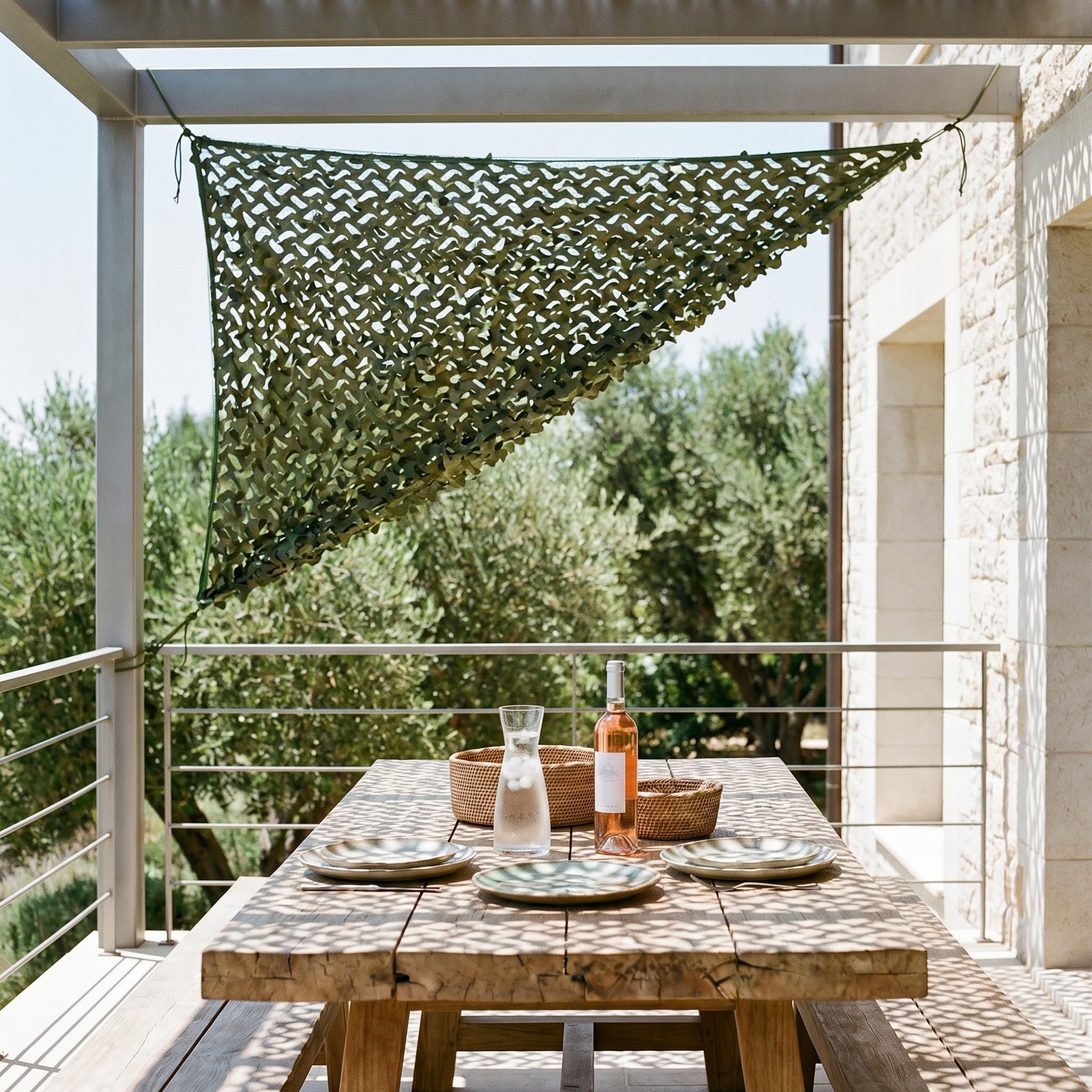 TheFrenchNets woodland triangle shade net tied between two trees and a wall.